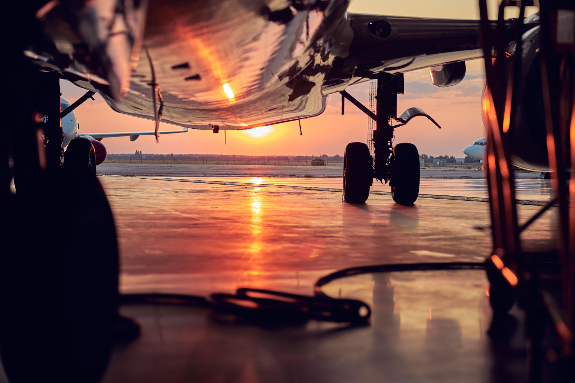 Aircraft undercarriage and landing gear on tarmac at sunset